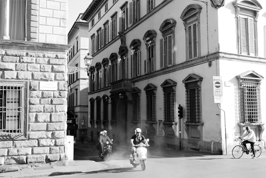 grayscale photo of 2 women walking on sidewalk near building in Firenze Italy