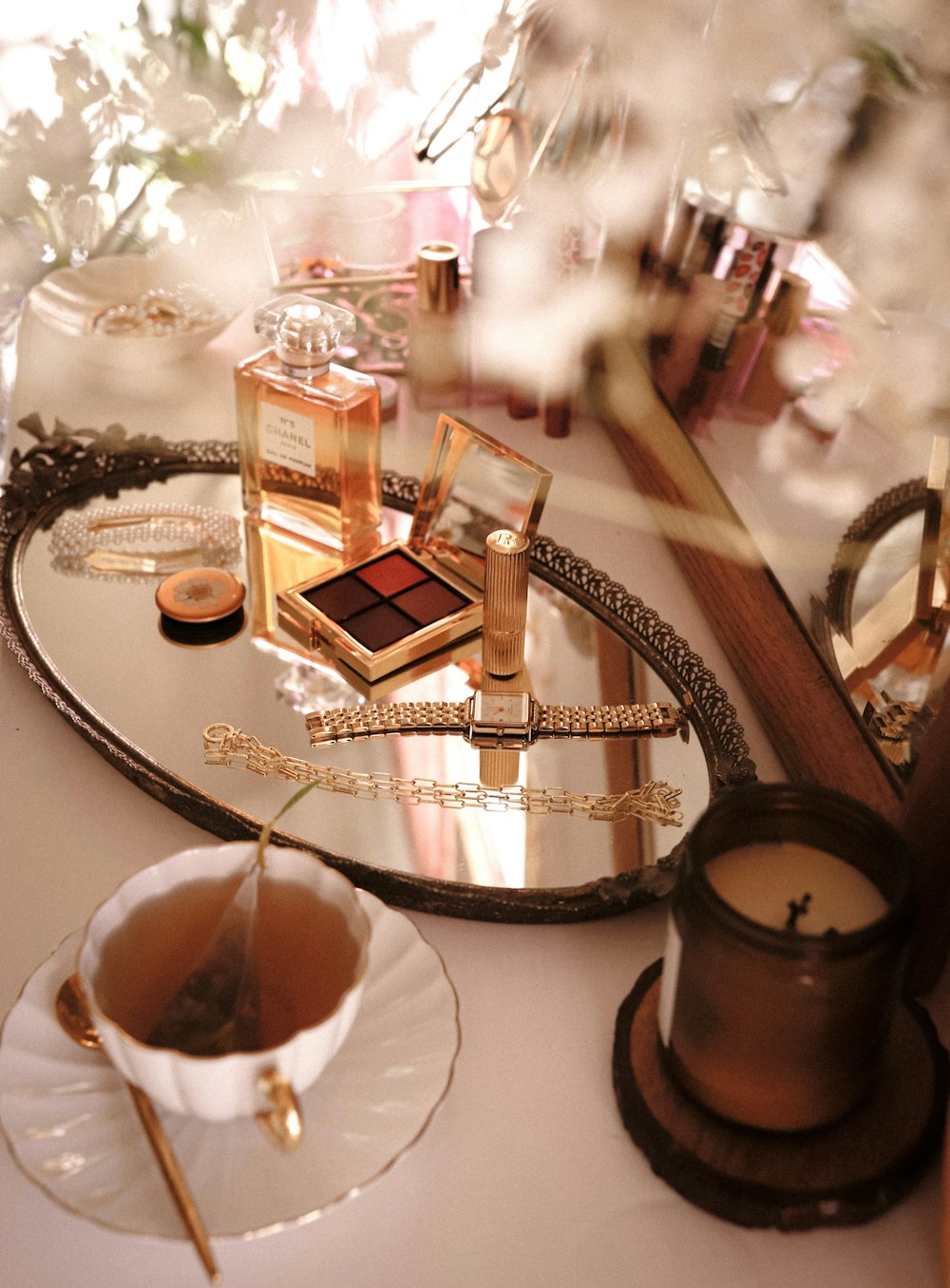Frasco de perfume dorado y blanco sobre mesa redonda de cristal