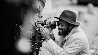 man in white dress shirt holding black dslr camera