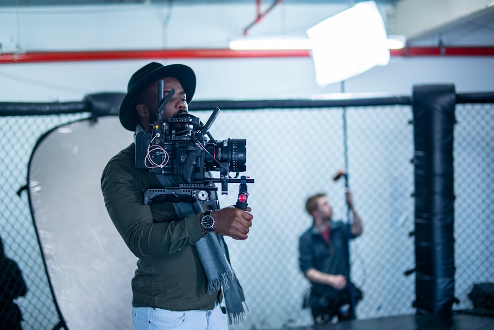 man in black jacket holding black dslr camera