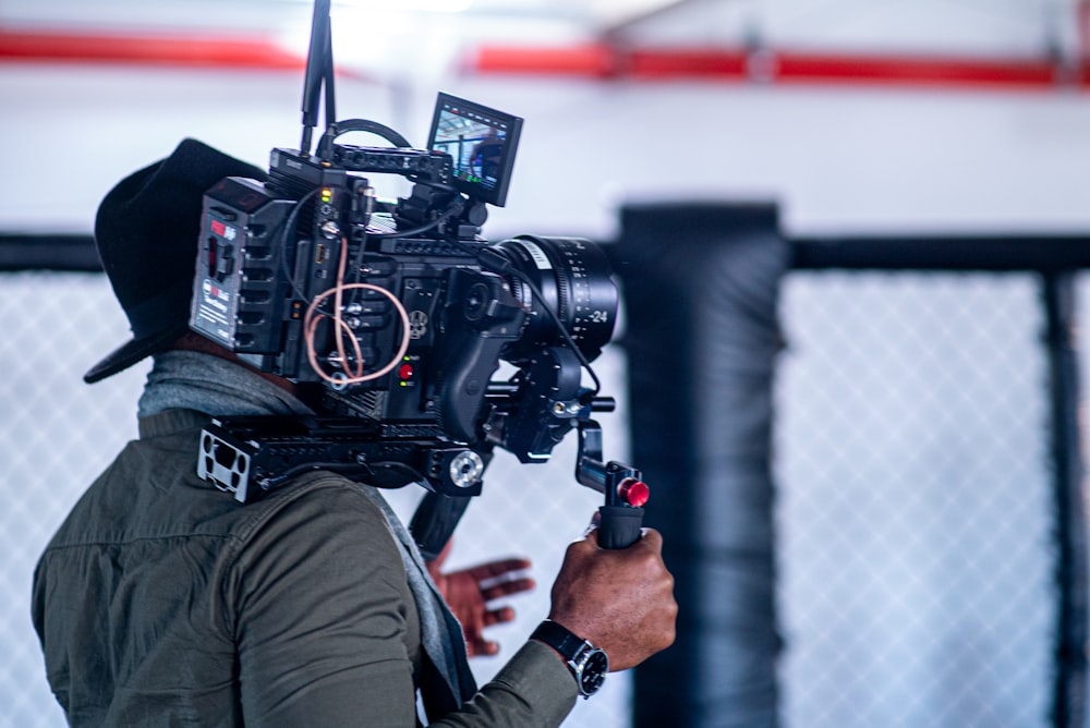 man in black jacket holding black video camera