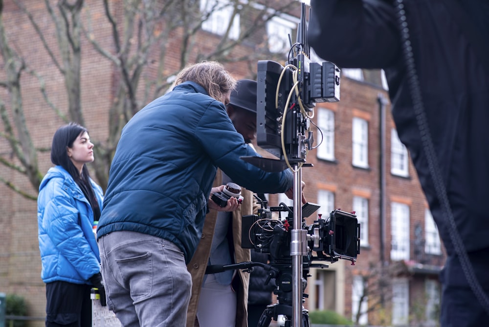 man in blue long sleeve shirt and brown pants holding black dslr camera