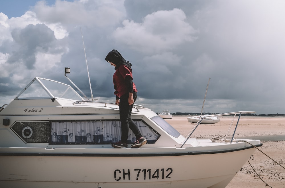 man in red jacket and black helmet riding white and blue boat during daytime