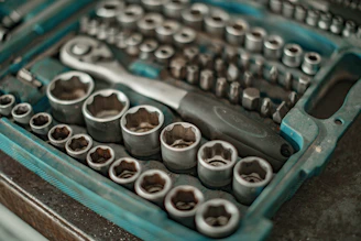 A 3D printed socket set arranged neatly on a workbench with automotive parts in the background.