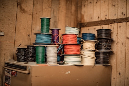 blue and green thread on brown wooden shelf