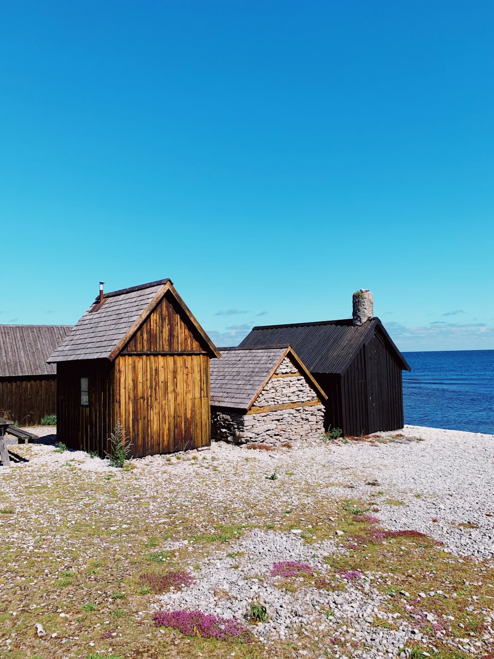 brown wooden house near body of water during daytime