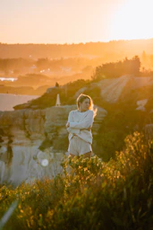 woman in white long sleeve shirt standing on green grass field during daytime
