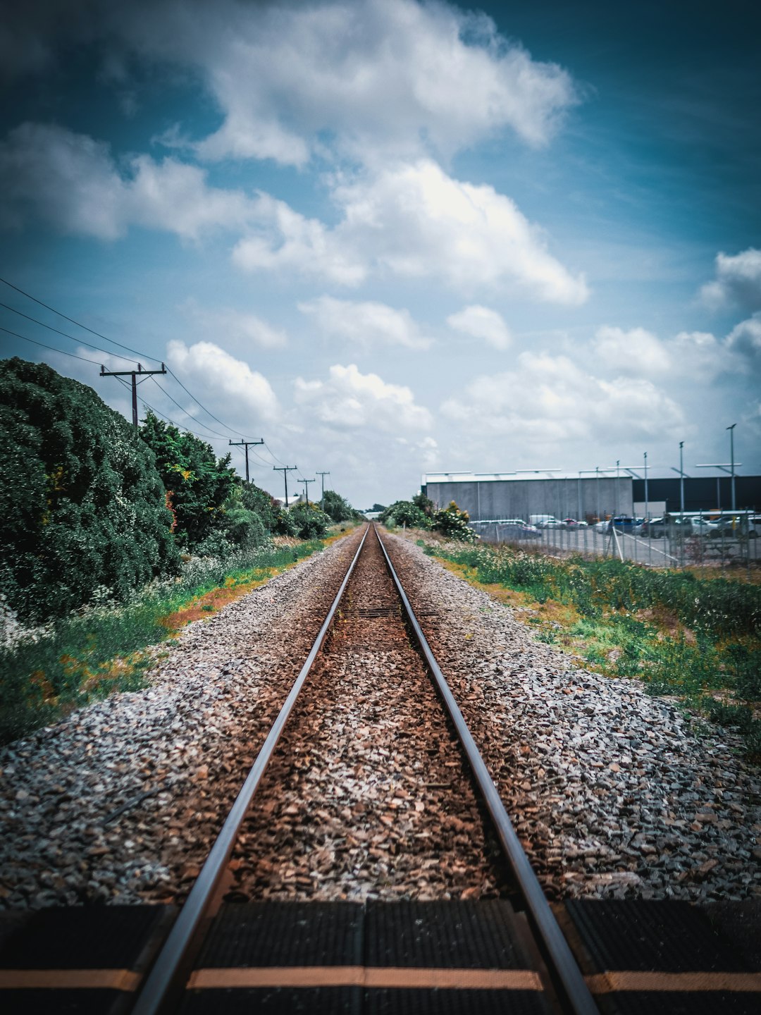 train rail under cloudy sky during daytime