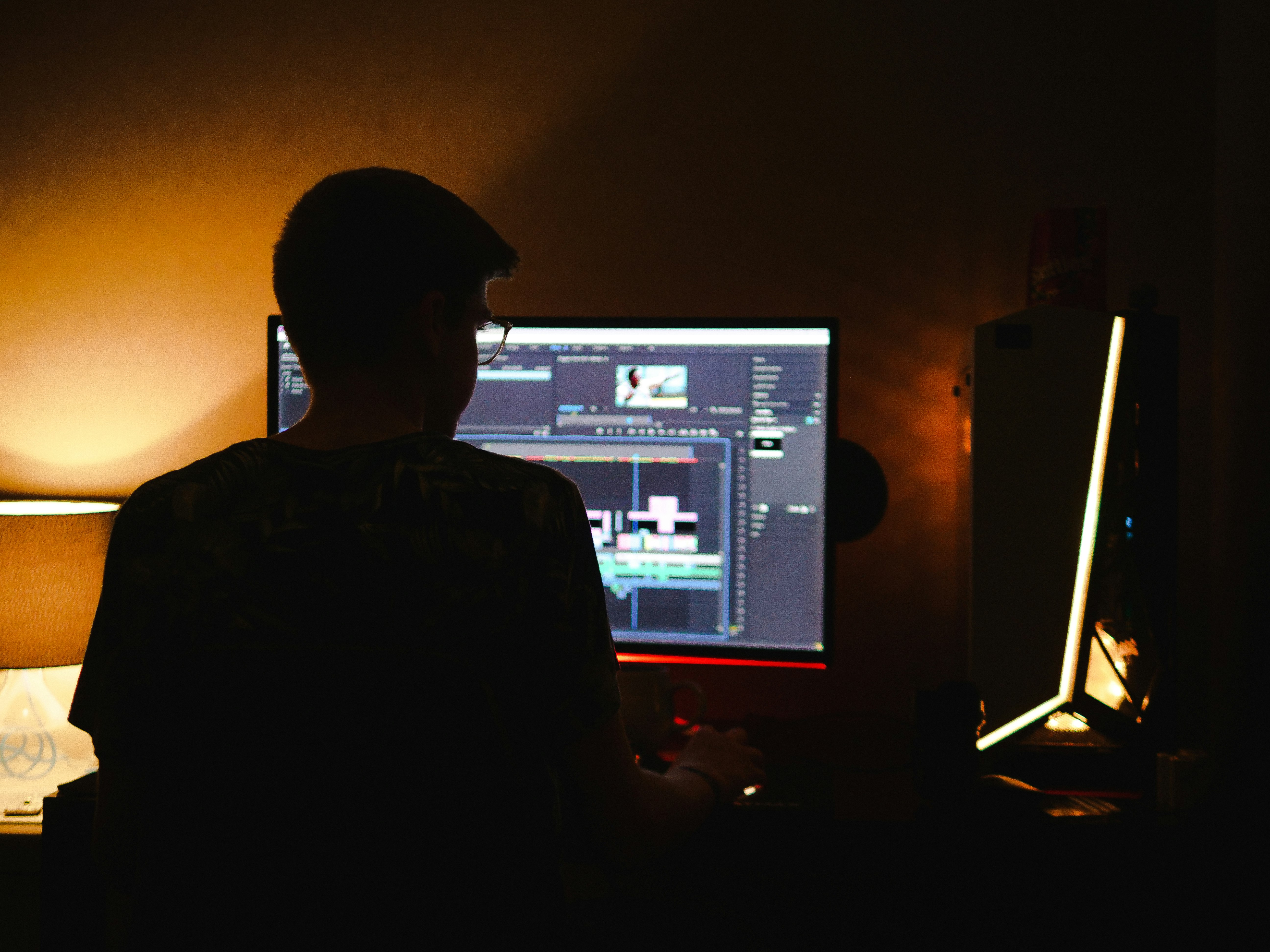 man in black shirt sitting in front of computer