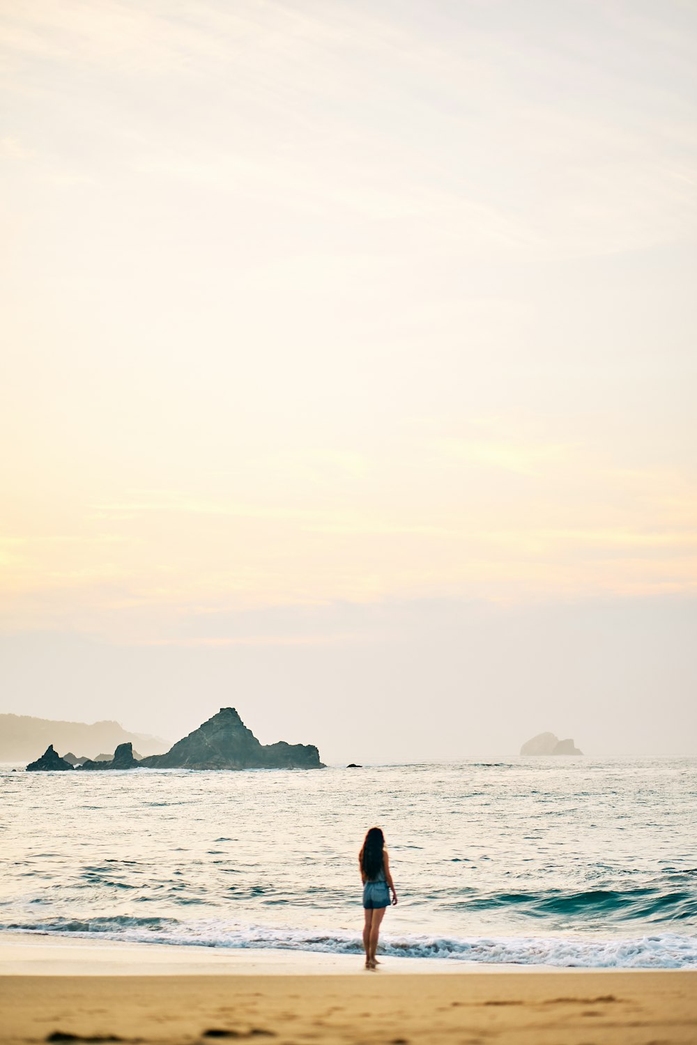 silhouette of person standing on sea shore during daytime