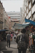 A backpacker exploring a colorful street market in an affordable travel destination.