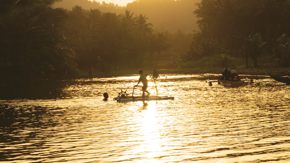 2 people riding on boat on lake during sunset