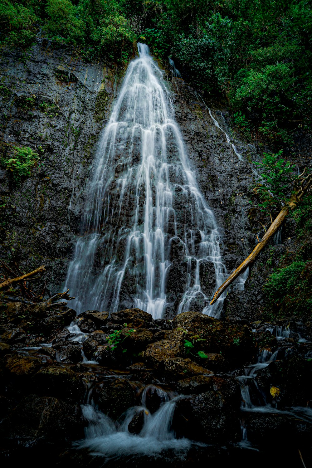 water falls on brown and green rock