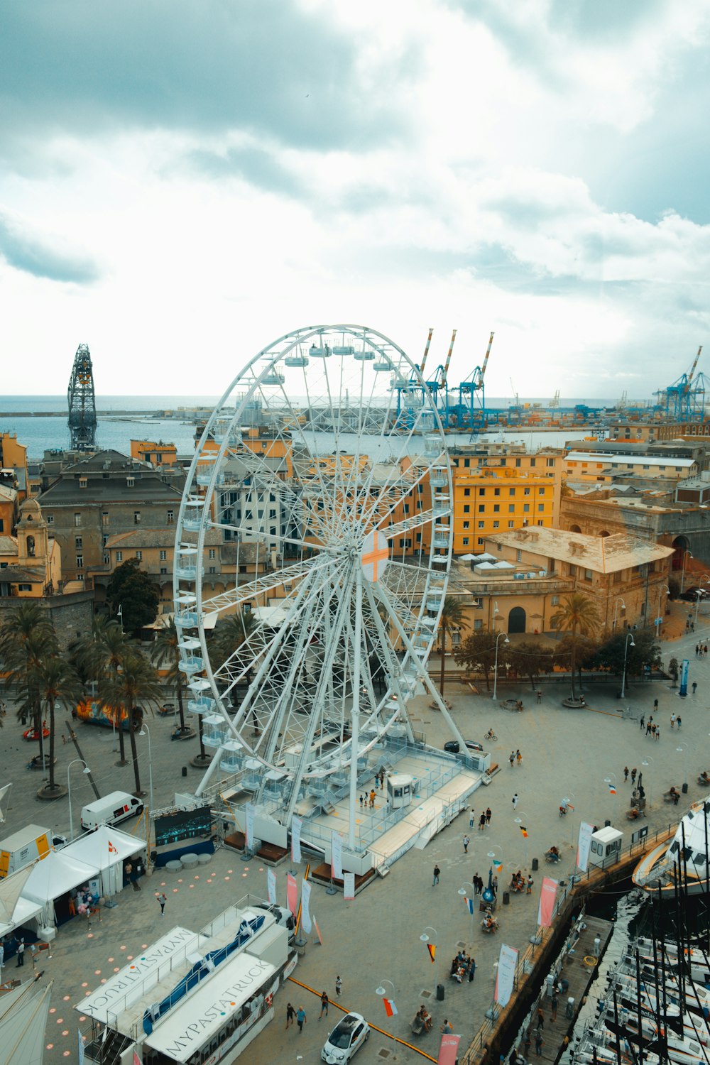 people walking on the street near ferris wheel during daytime