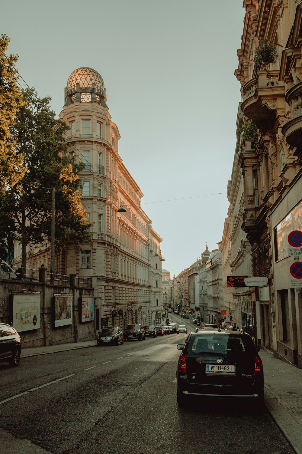 cars parked on side of the road near buildings during daytime