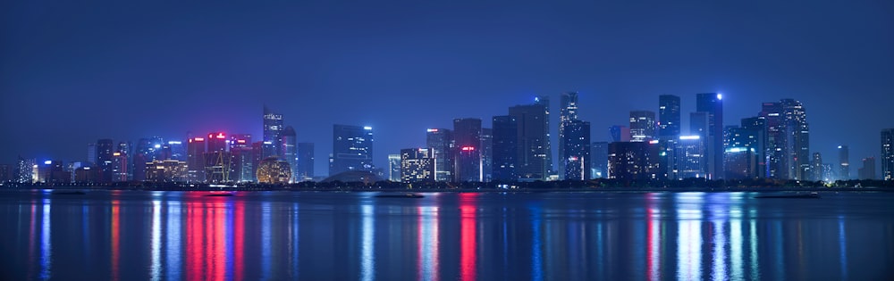 city skyline across body of water during night time