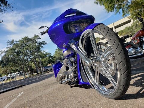 Motorcycle parked with vibrant aftermarket parts shining under sunlight.