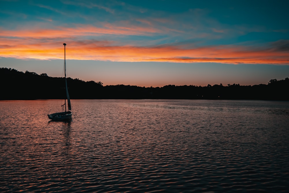 silhouette of boat on sea during sunset