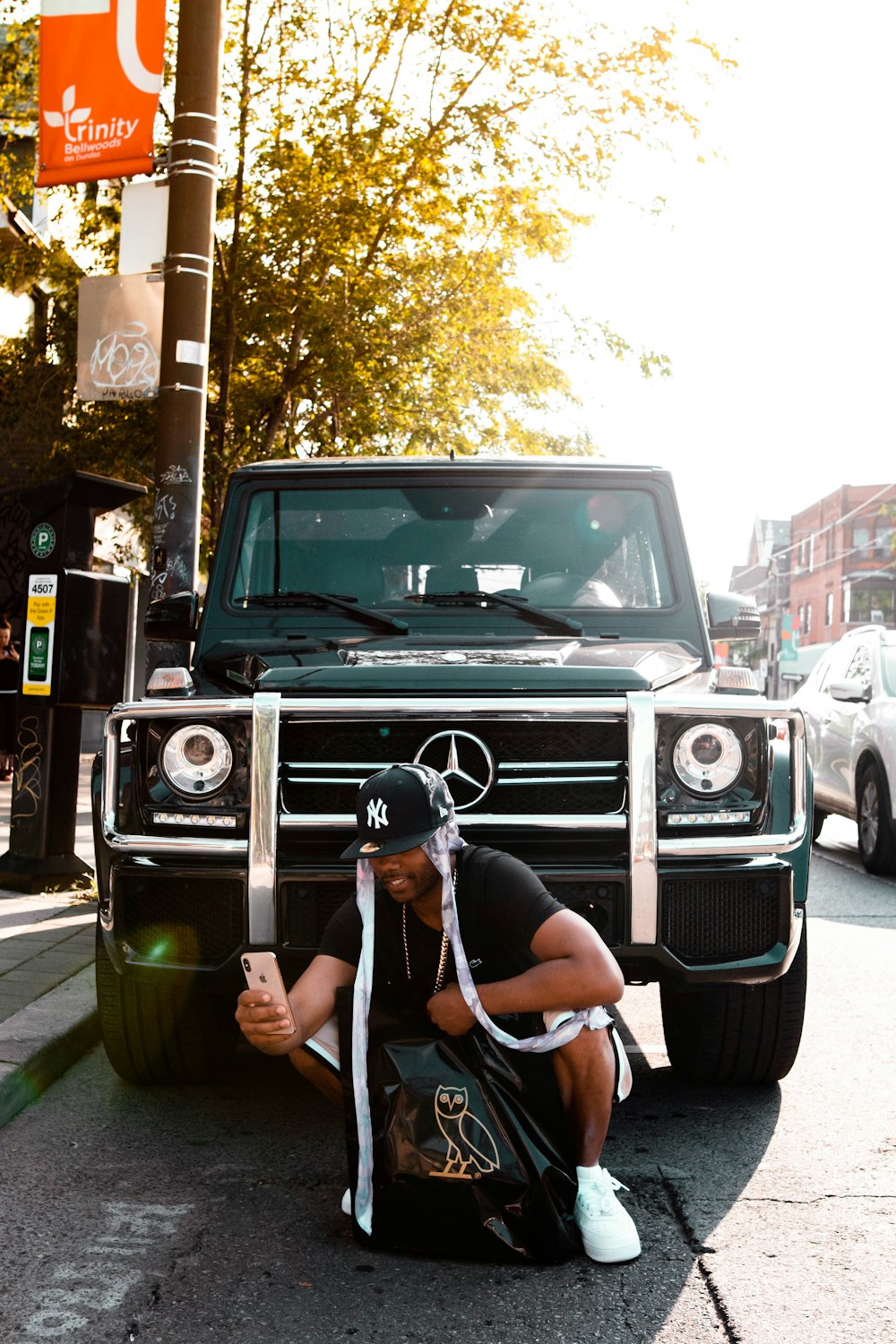 woman in white tank top sitting on green mercedes benz g class