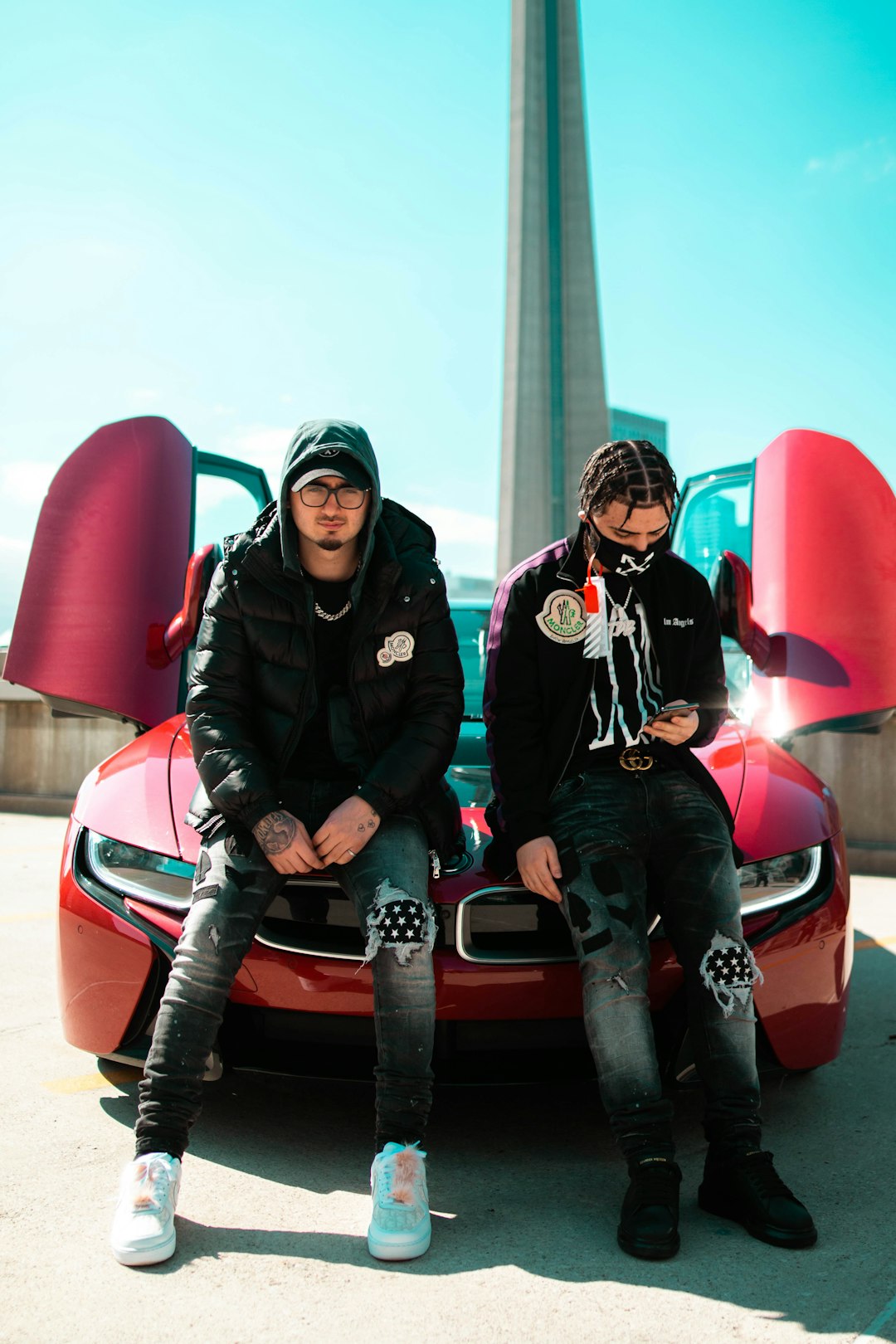 2 men in black jacket riding red car