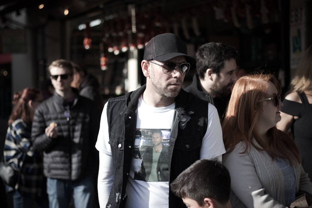 man in black leather jacket standing beside woman in white shirt