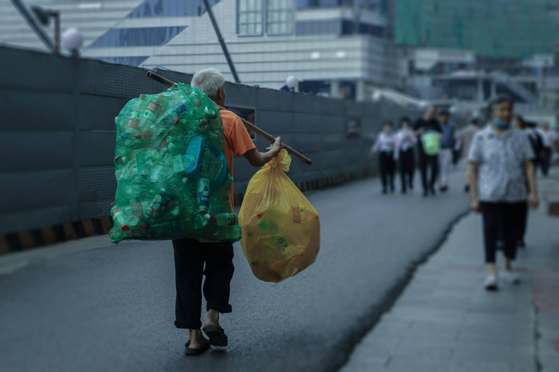 woman in blue and white floral dress holding yellow plastic bag