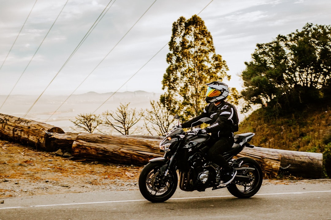 man in black motorcycle helmet riding motorcycle on road during daytime