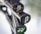 Close-up of the handles of three tennis rackets leaning together, with visible brand markings. The handles are black with textured grips, and each end cap has a unique design or logo, one being green and another featuring the word 'AIR'. The background is out of focus, highlighting the rackets.