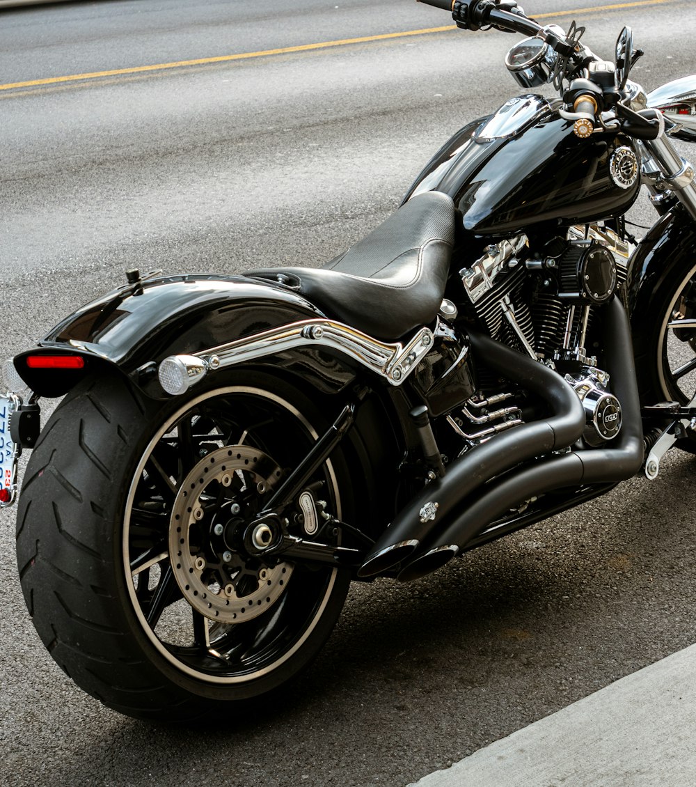 black and silver cruiser motorcycle on gray asphalt road