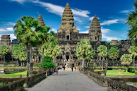 people walking on park near trees and building during daytime