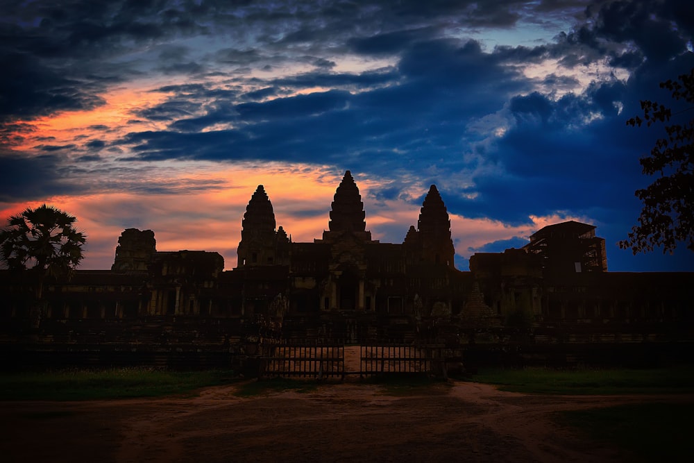 silhouette of building under cloudy sky during sunset