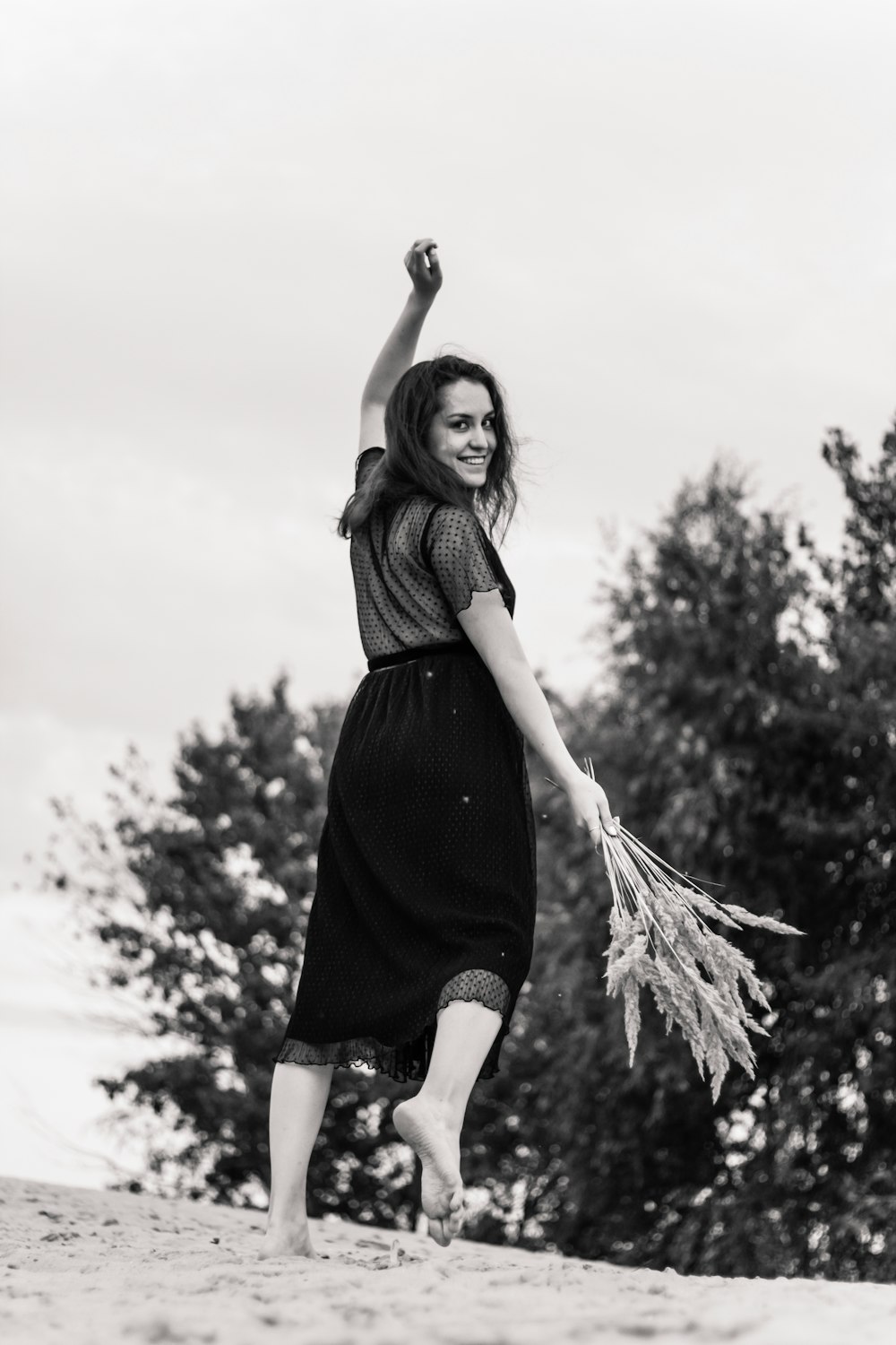 woman in black dress standing and smiling