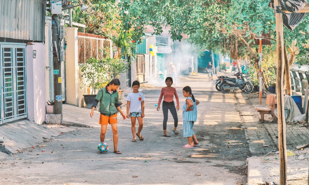 2 boys and girl walking on sidewalk during daytime