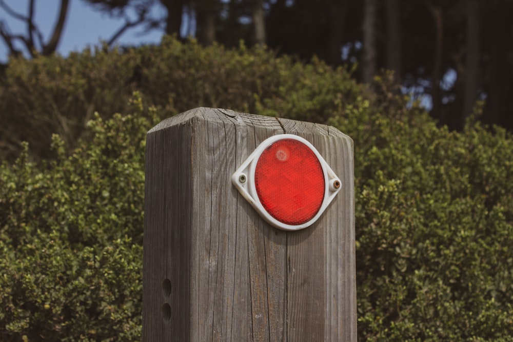 red and white square device on brown wooden post