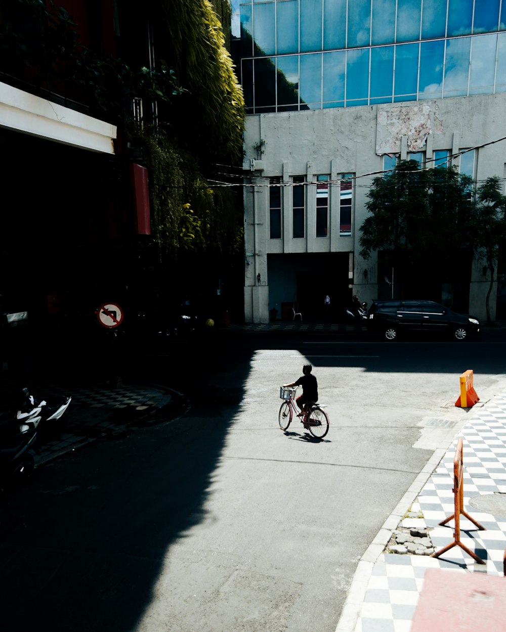 man in black jacket riding bicycle on road during daytime