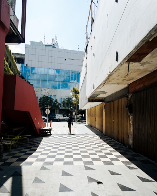 people walking on sidewalk near building during daytime in Surabaya Indonesia