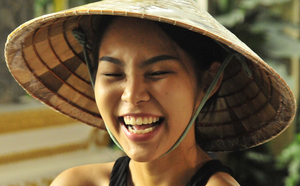 woman in black tank top wearing brown and white hat