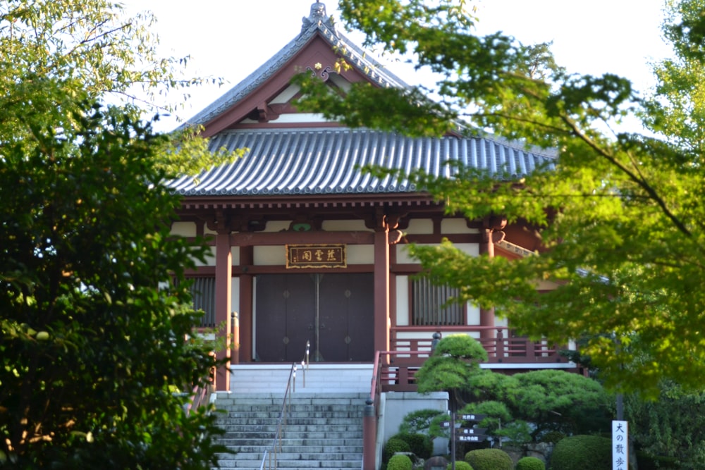 brown and white wooden house surrounded by green trees during daytime