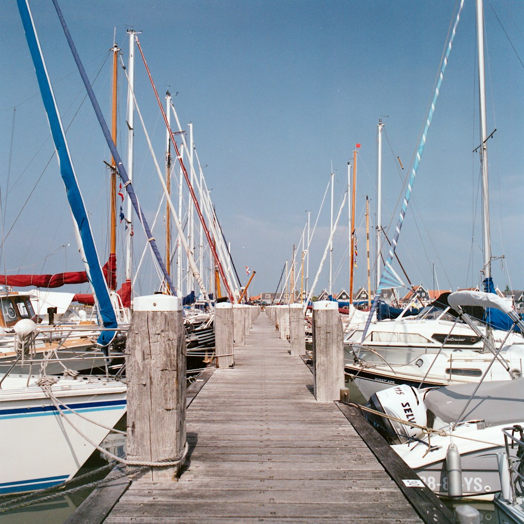 white and blue boat on dock during daytime