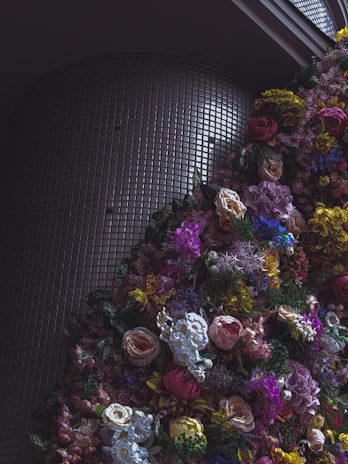 A modern geometric flower wall with mixed pastel blooms and greenery accents.