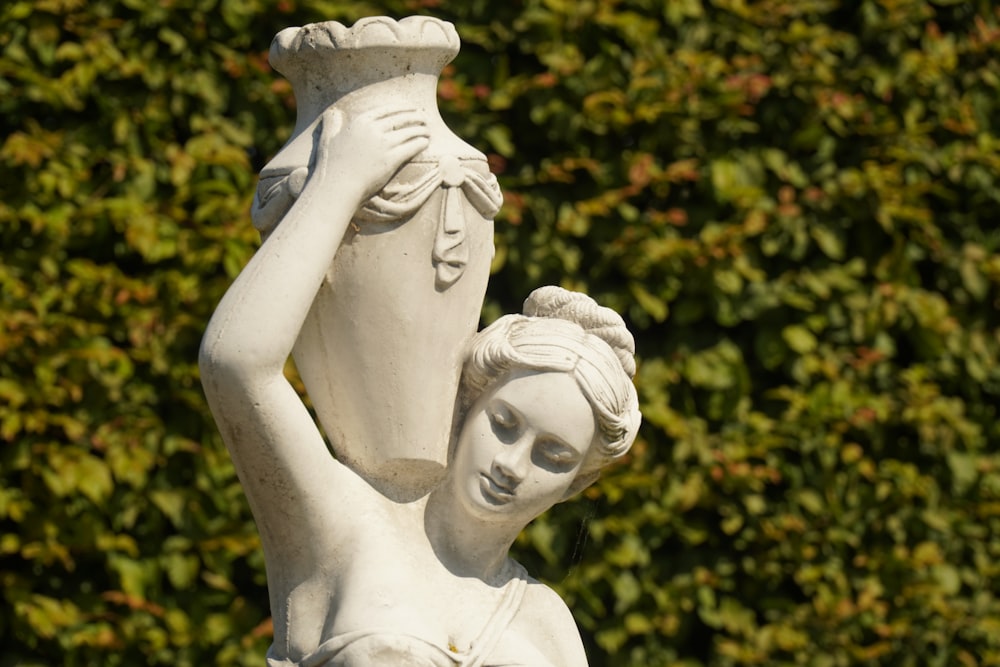 white angel statue near green plants