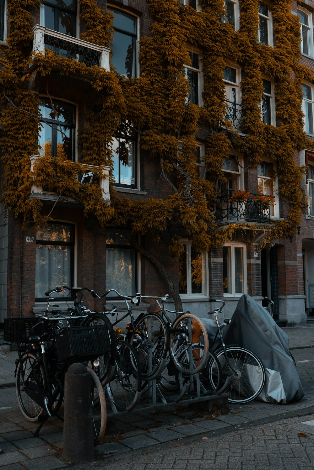 black city bikes parked beside brown concrete building during daytime