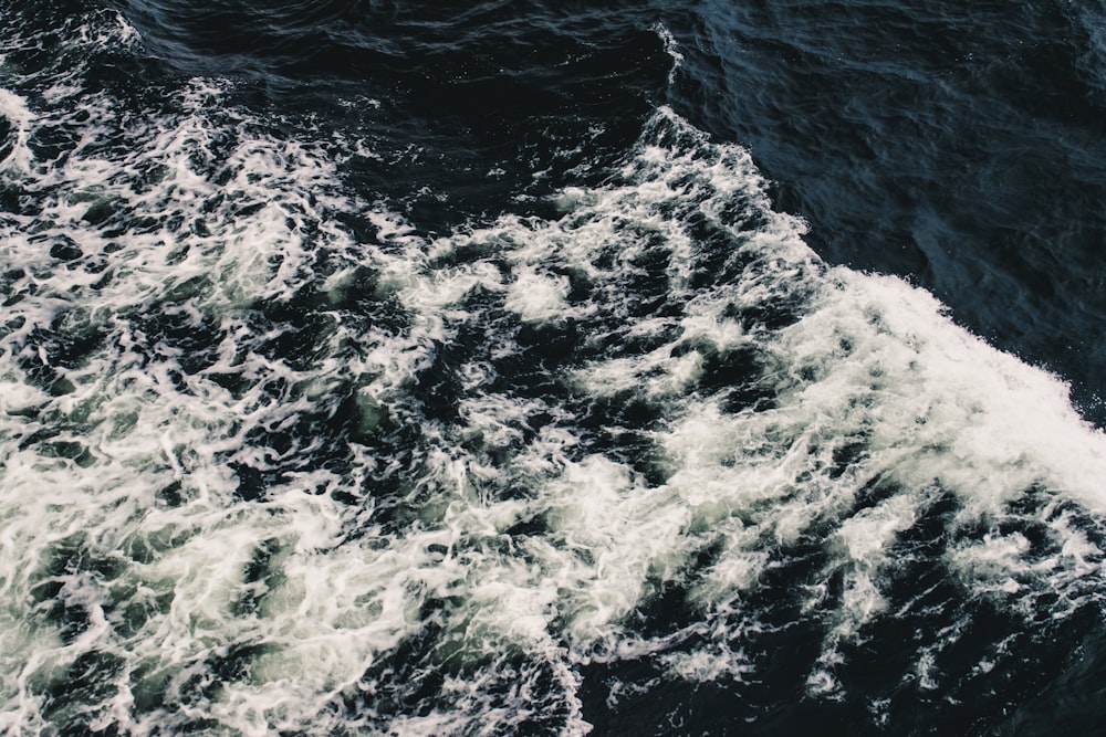 water waves hitting rocks during daytime