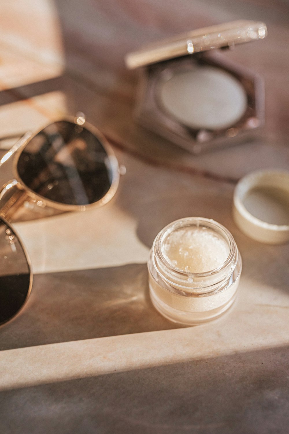 lunettes de soleil noires à côté d’un bocal en verre transparent