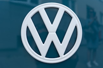 A Volkswagen logo in white is prominently displayed against a dark teal background.