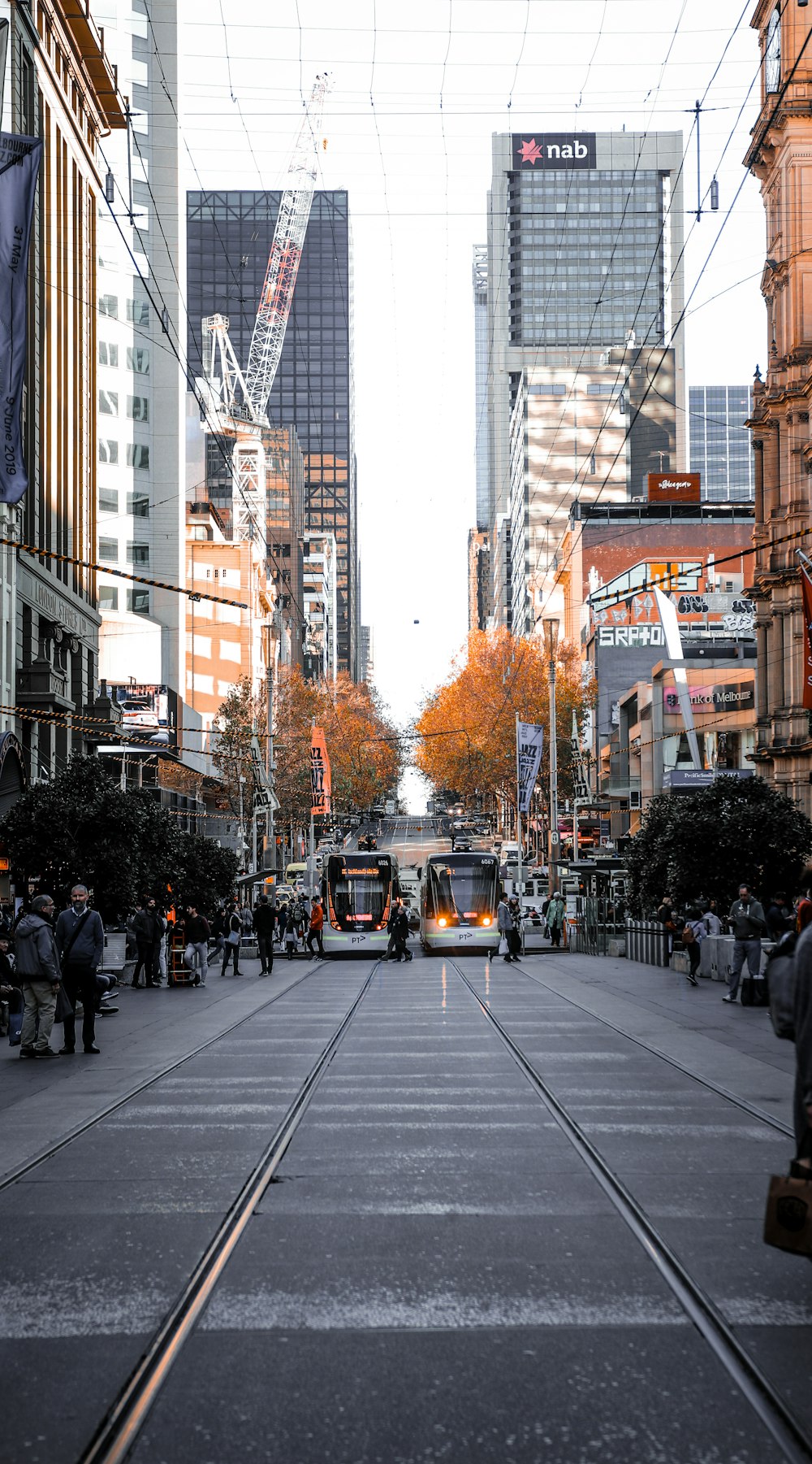 people walking on sidewalk near high rise buildings during daytime