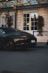 A stylish car ready for pickup service parked in front of a villa entrance.