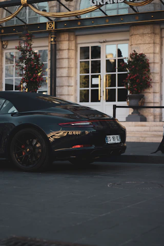 A sleek black and gold luxury transport vehicle parked at a concert venue entrance during sunset.
