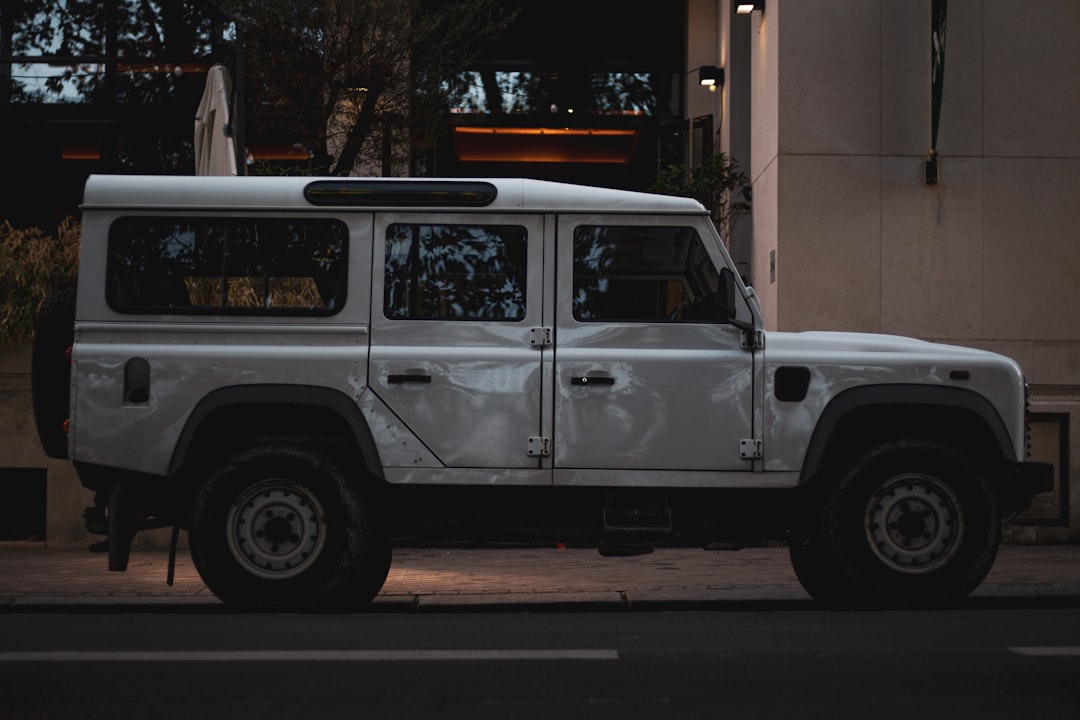 white suv parked near red building