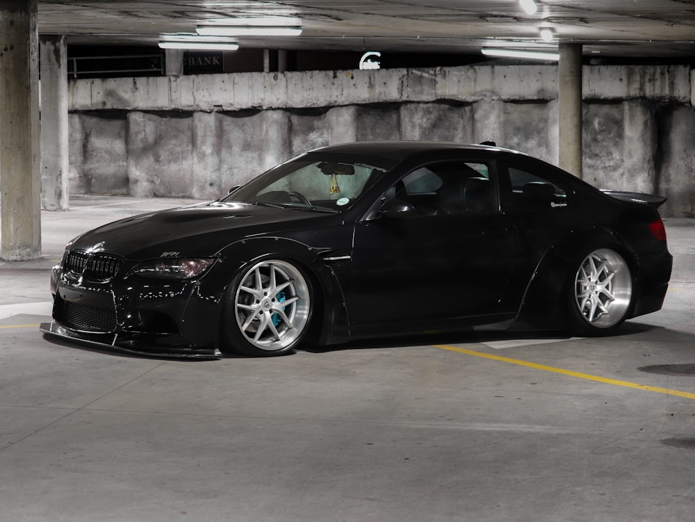 black porsche 911 parked on gray concrete pavement